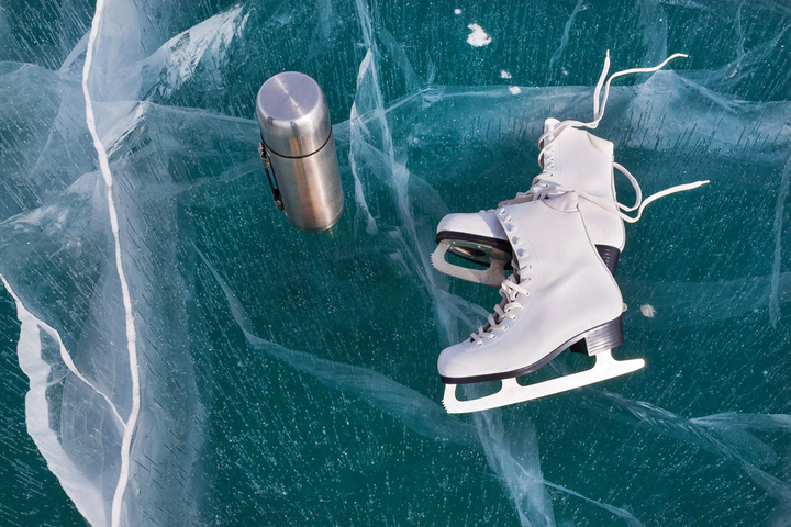 Professional ice skating instructor demonstrating elegant technique on pristine ice rink
